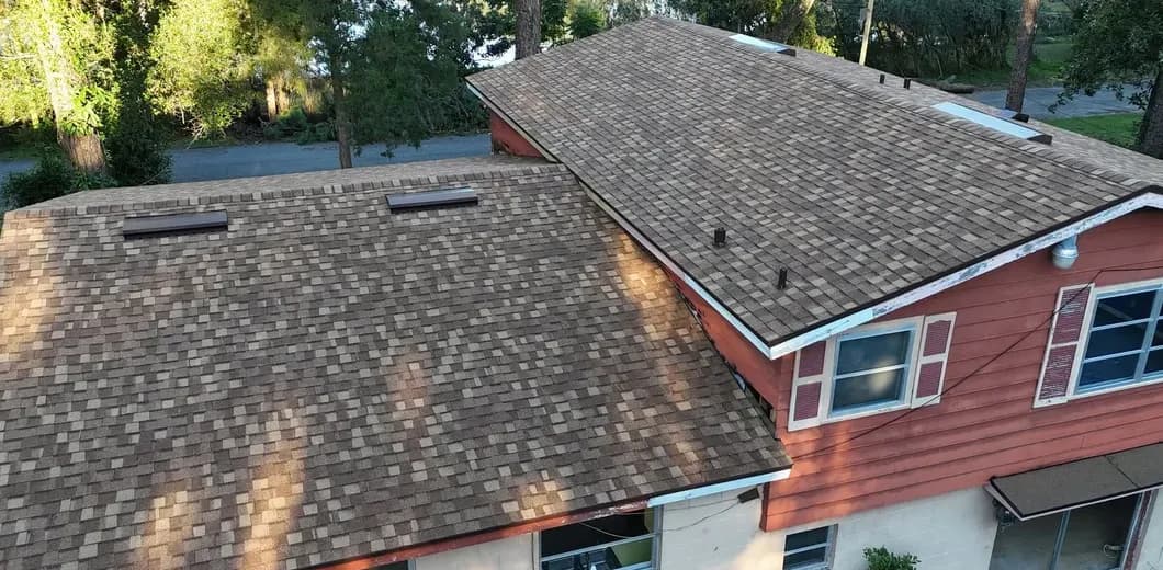 New asphalt shingle roof with ridge vents and fresh drip edge on a two-story home